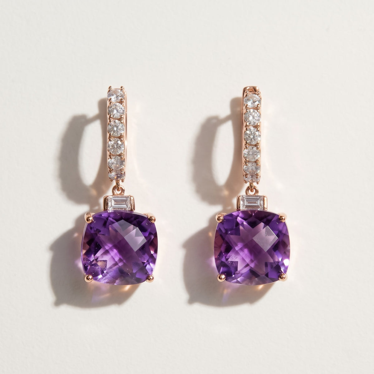 Pair of 14K rose gold amethyst drop earrings featuring 7.67 CTW cushion-cut purple amethysts and white sapphire huggie hoops