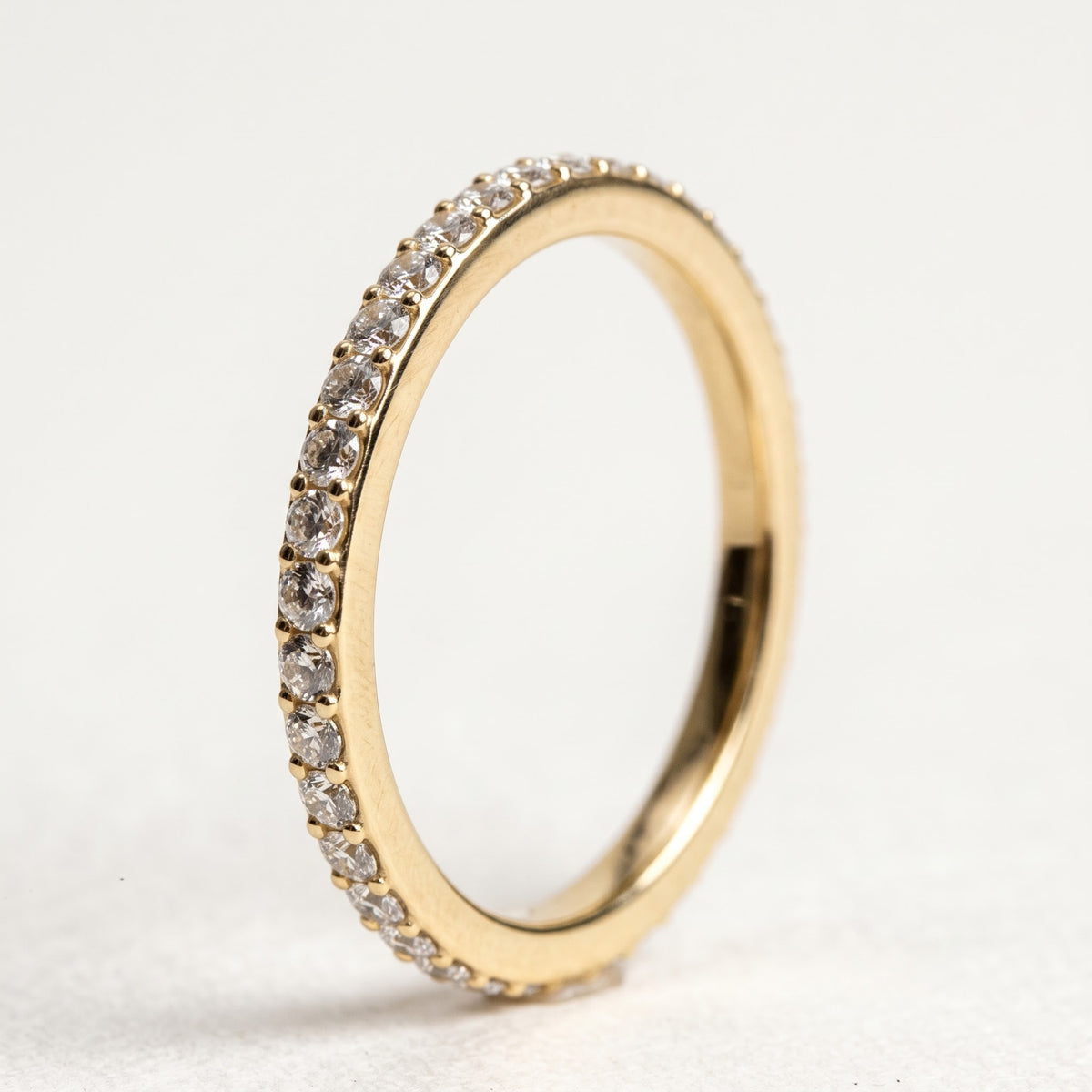 Side profile of sleek thin 1.0 CT Approx. round lab-grown diamond band ring crafted for stacking or solo wear