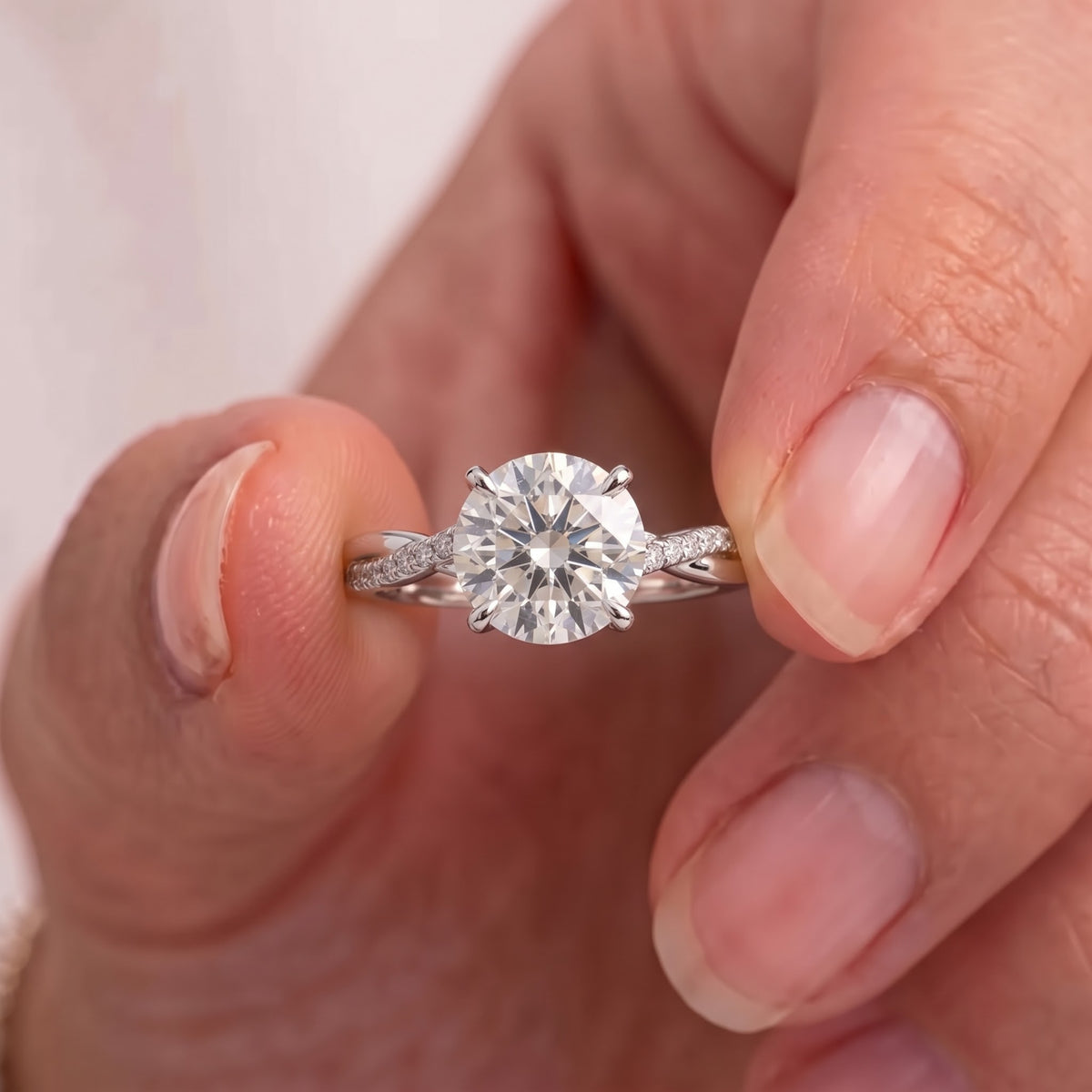 Hand holding a 2.50 CT Approx. VVS/VS lab-grown diamond ring with a twisted vine pavé band and classic claw prongs.