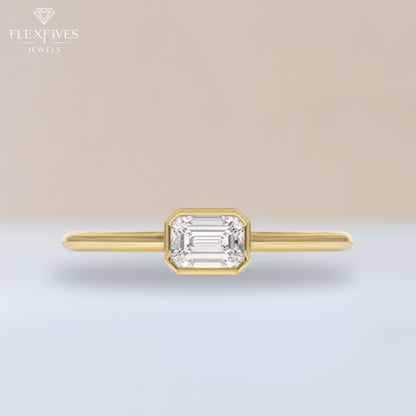 Gold ring with emerald-cut diamond on a gradient background, branded 'Flexfives'.