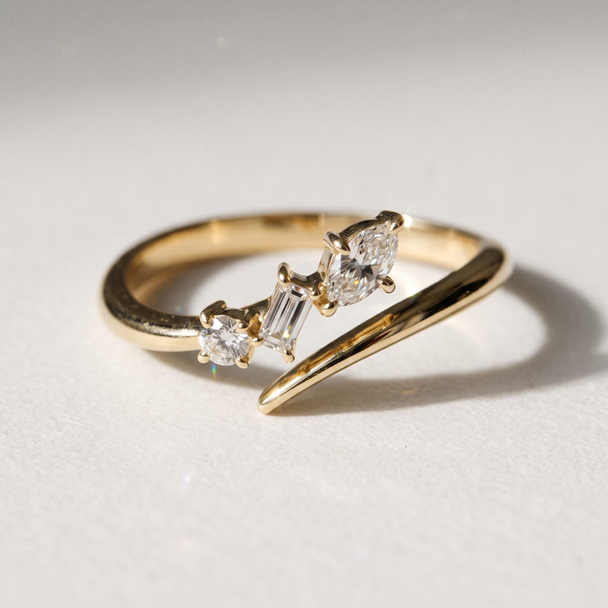 Frontal studio view of Orion 14K yellow gold diamond bypass ring featuring 0.19 TCW marquise, baguette, and round lab diamonds