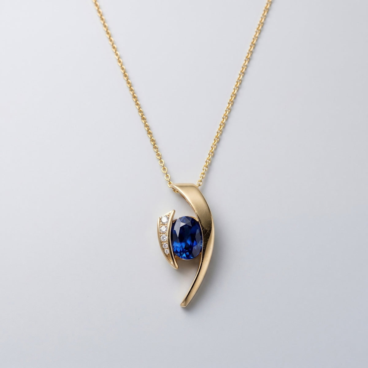 Oval tanzanite and diamond floating pendant necklace in yellow gold