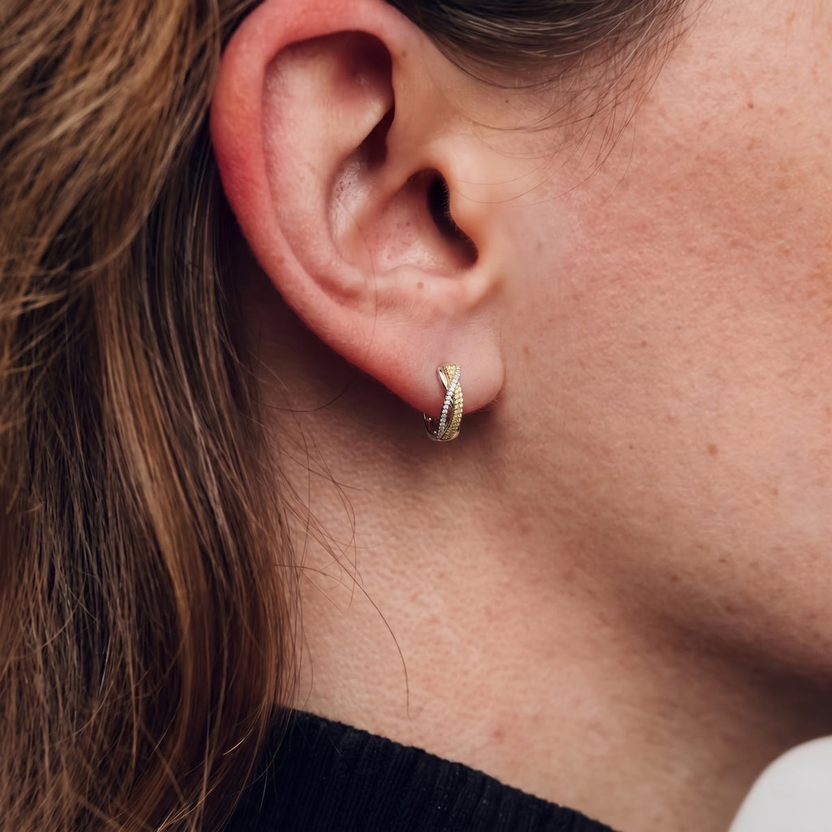Two-tone gold diamond huggie earrings styled for everyday wear